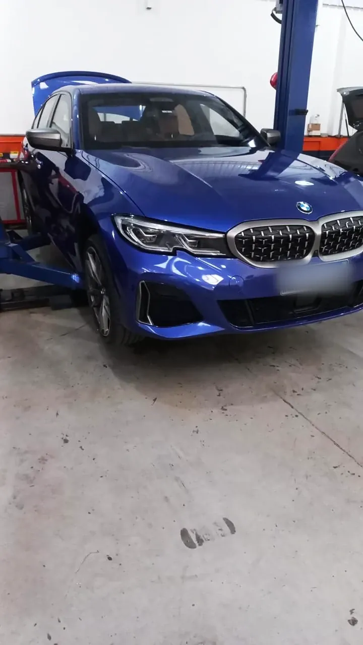 BMW azul no elevador da oficina
