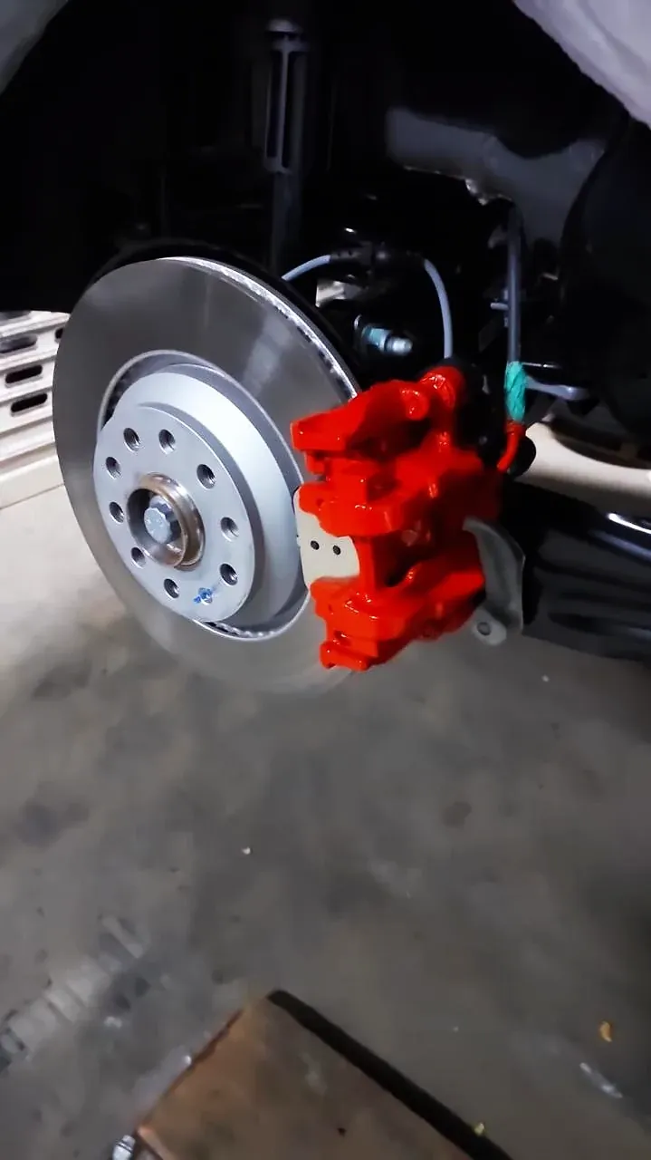 Disco de freio e pinça vermelha montados no cubo do carro