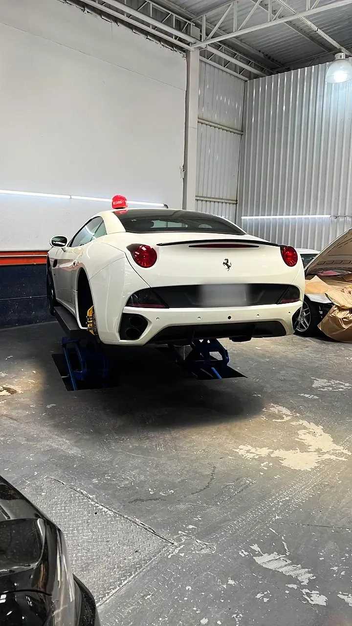 Ferrari California branca no elevador da oficina da RM