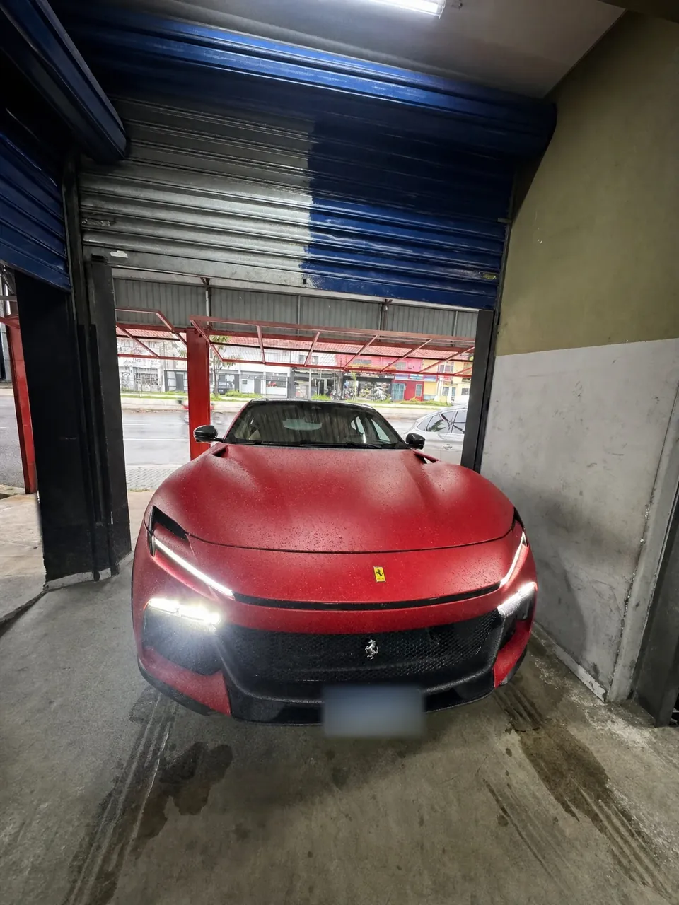 Ferrari Purosangue vermelha fosca entrando na oficina da RM, com os faróis acesos