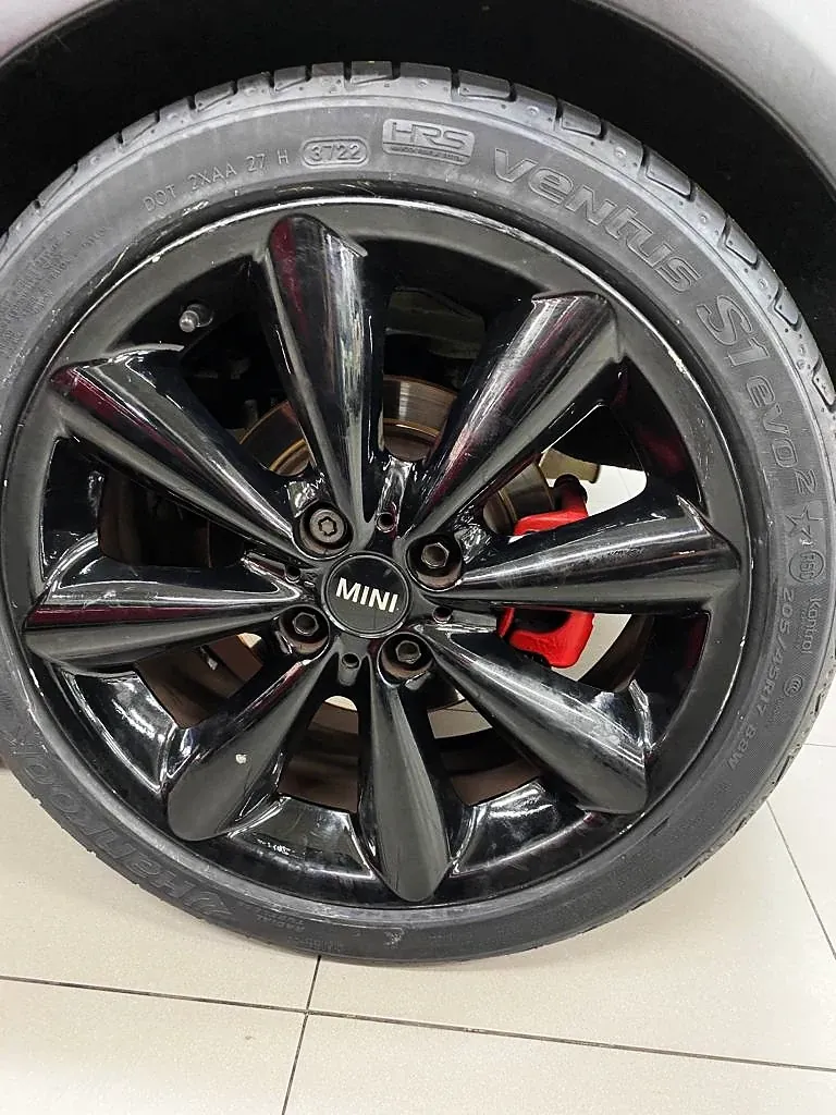 Mini com roda pintada de preto e pinça de freio vermelha