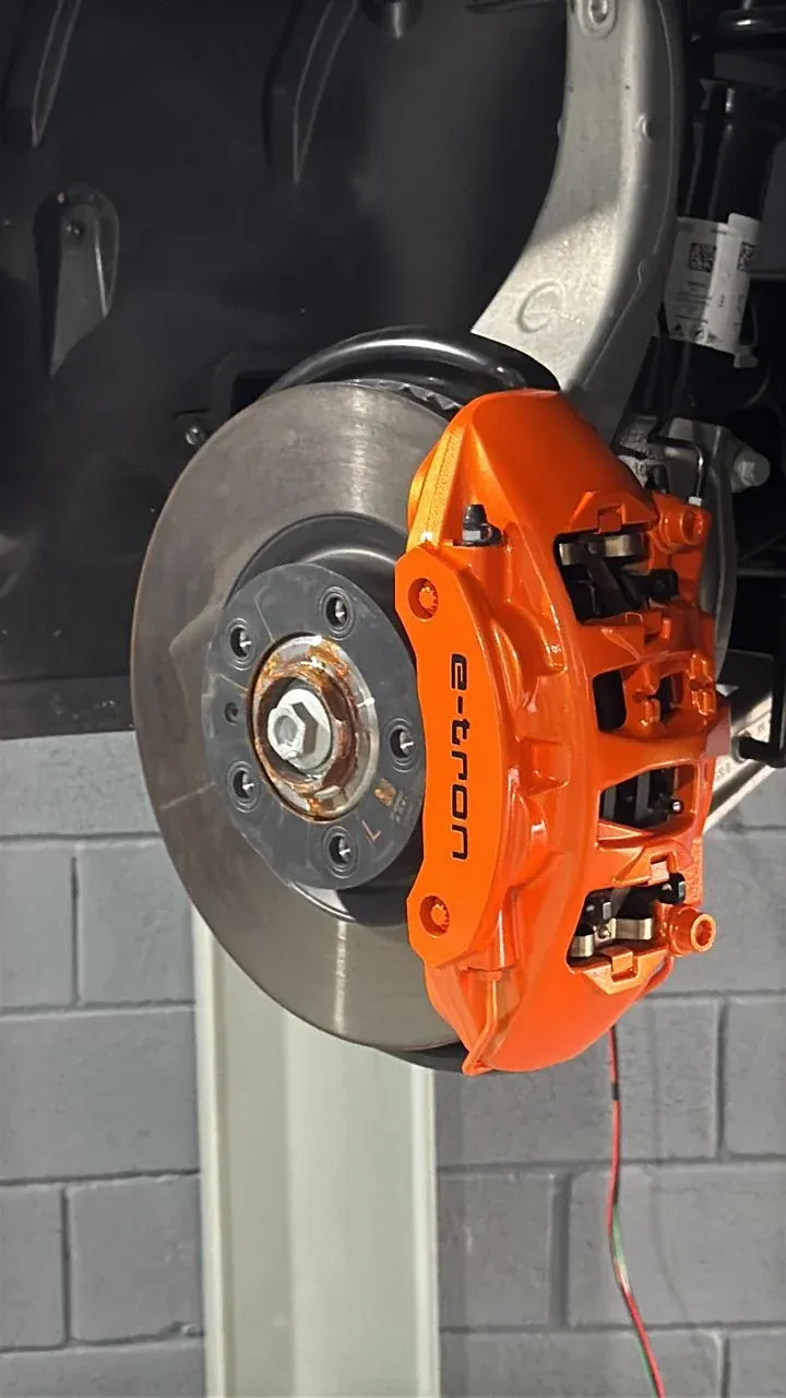 Pinça de freio Audi e-tron pintada de laranja, montada no cubo com o disco