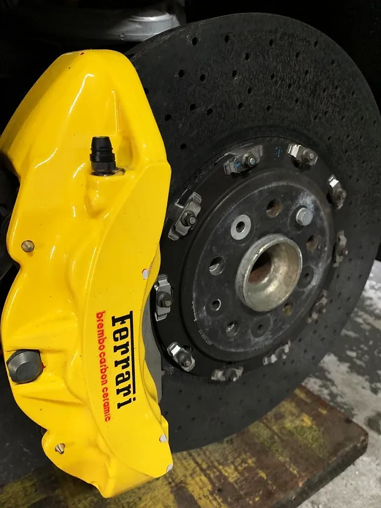 Pinça Ferrari em amarelo sobre disco de freio