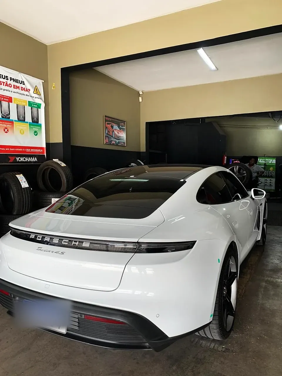Porsche Taycan branco, traseira, na oficina