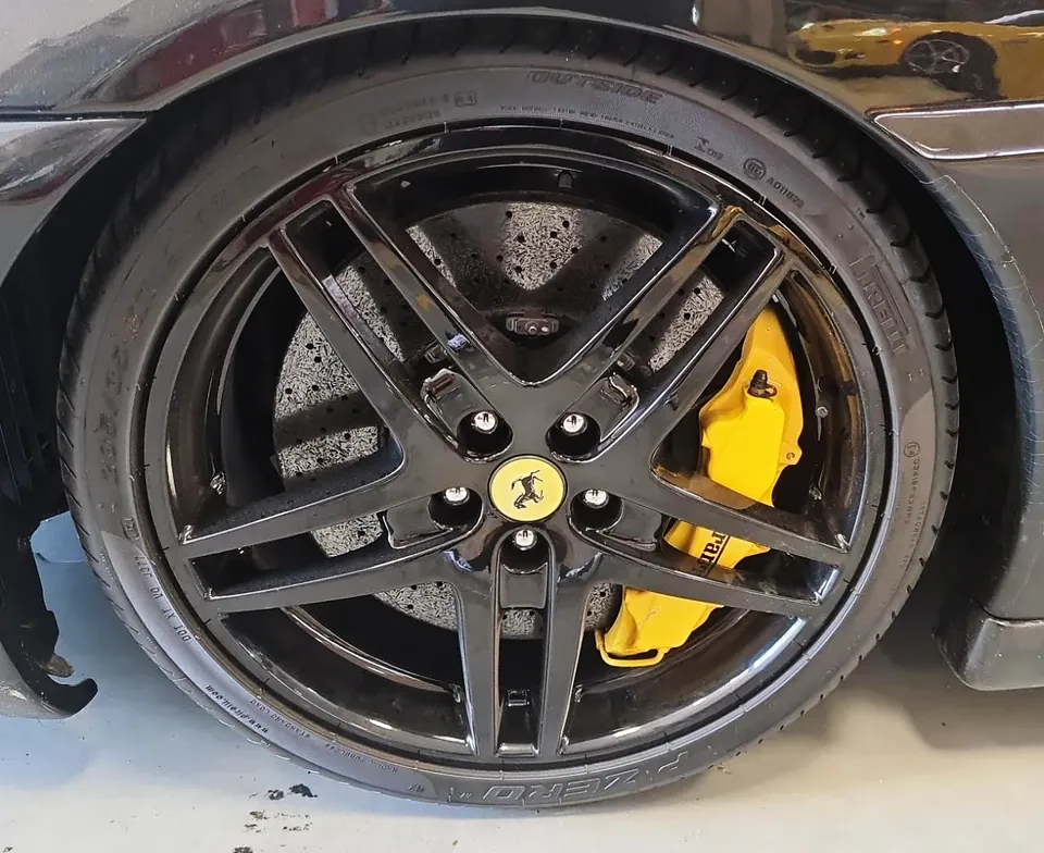 Roda Ferrari pintada de preto com pinça de freio amarela