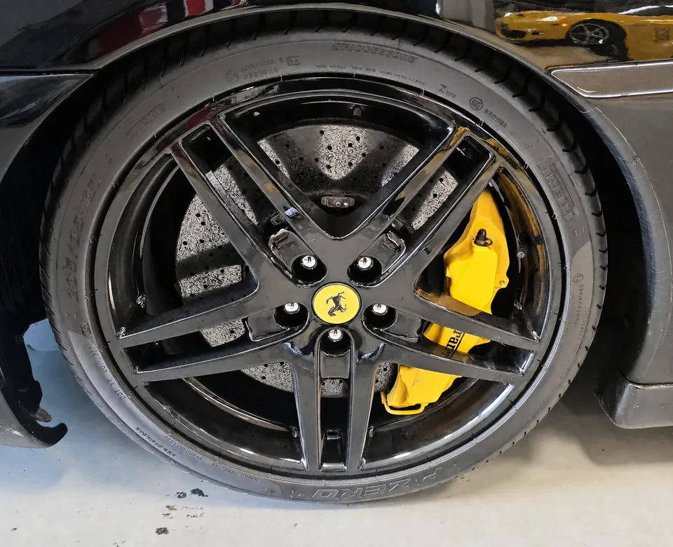 Roda Ferrari pintada de preto com pinça de freio amarela
