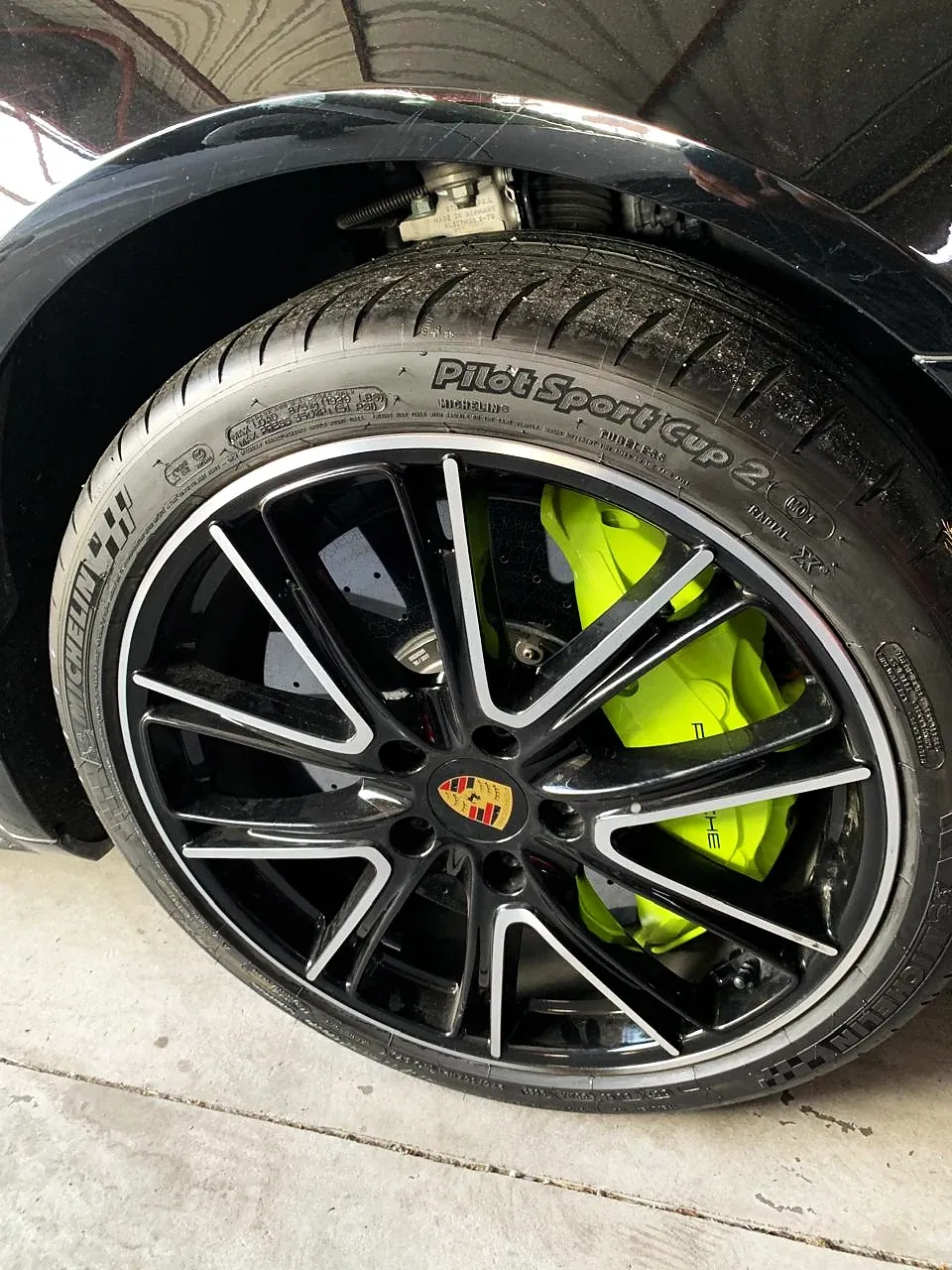Roda Porsche preta com pinça verde-limão, em detalhe